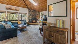 A cozy living room with a fireplace, a sofa set, a wooden cabinet, and a large mirror. - 6 Lynx Sunriver (Sunriver)