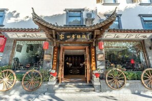 A traditional Chinese building entrance with a tiled roof, wooden doors, and decorative elements. - the Four Seasons the Inn (Lijiang)
