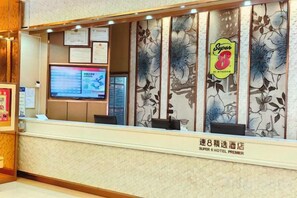 A hotel reception area with a digital display, a sign for 'Super 8 Hotel Premier,' and a floral design on the wall. - Super 8 Hotel Zepu Fatong Park (Zepu)