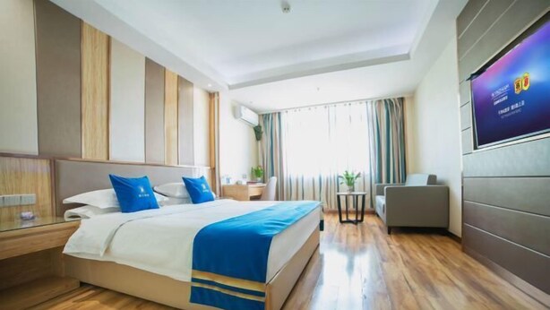 A hotel room with a bed, bedside table, TV, and a view of the outdoors. - Super 8 Hotel Zepu Fatong Park (Zepu)