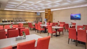 A hotel dining area with red chairs and tables, a buffet counter, and a television on the wall. - Super 8 Hotel Zepu Fatong Park (Zepu)