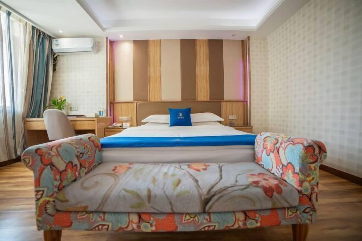 A hotel room with a bed, a desk, and a chair.
