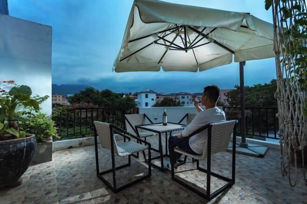 A patio with outdoor furniture, a table, and an umbrella.