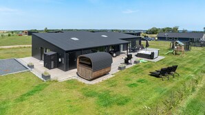 A modern house with a large deck, outdoor seating, and a hot tub. - Beautiful home in Børkop with sauna (Børkop)