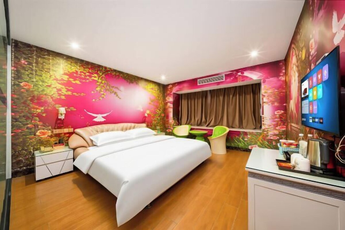 Un dormitorio con cama, escritorio, silla y televisor.