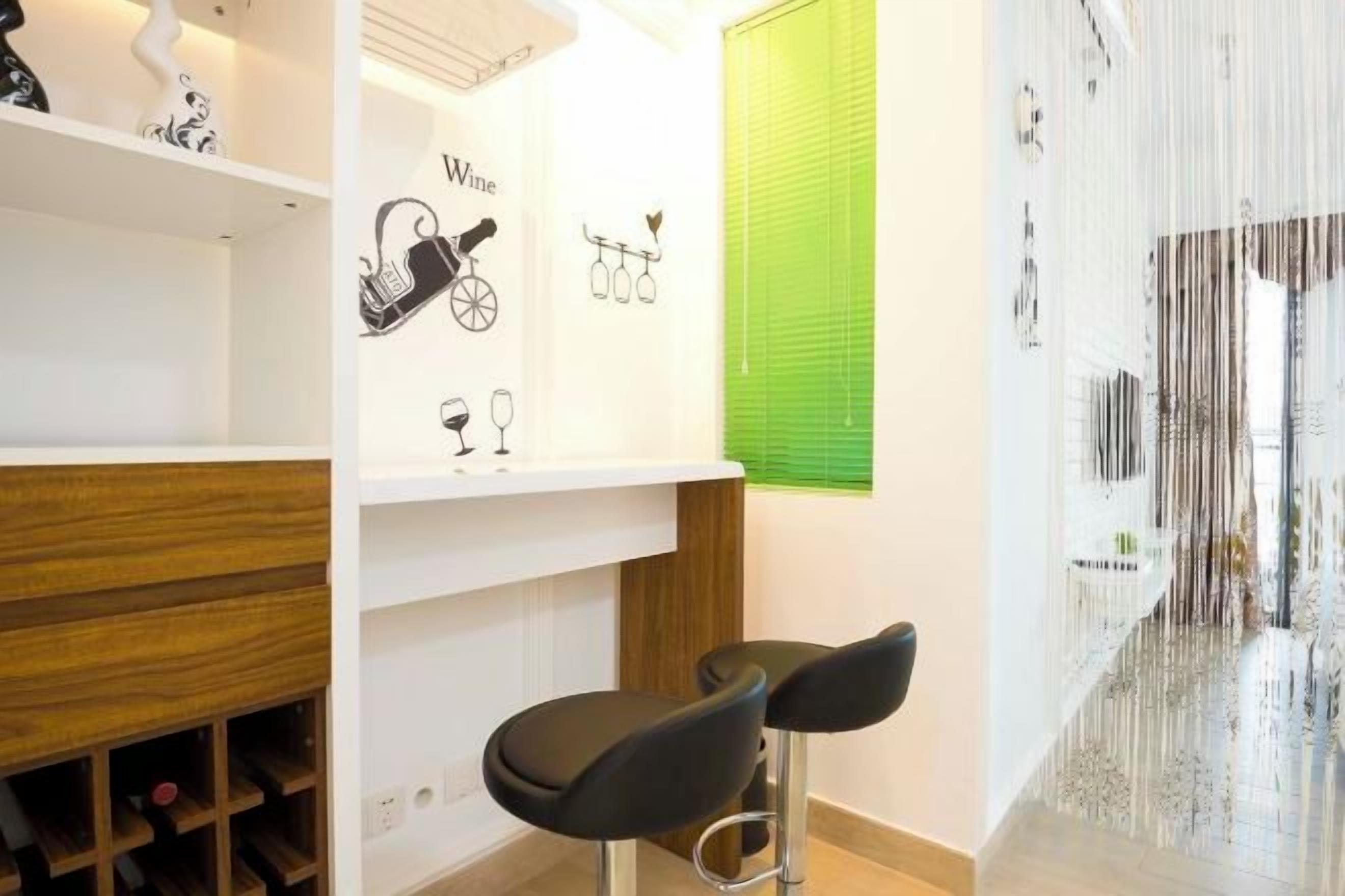 Quarto com adega, dois bancos altos e persiana verde.