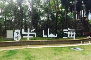 A sign with Chinese characters, a grassy area, and a concrete barrier.