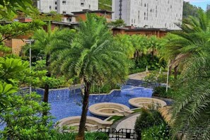 A pool area with multiple levels and palm trees.