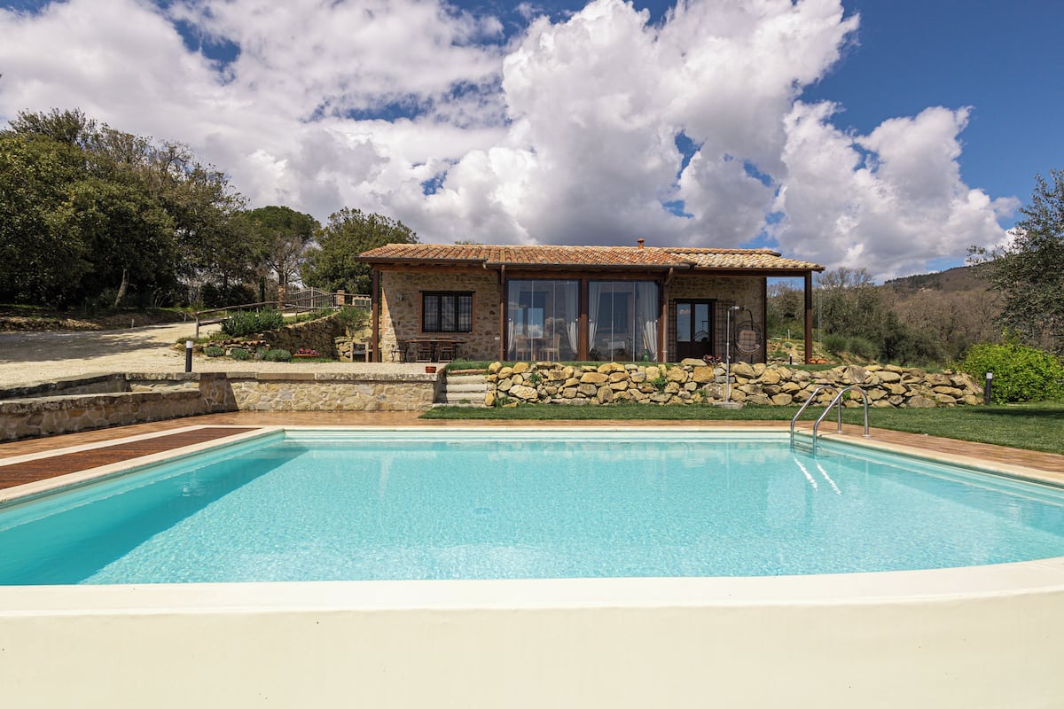 A swimming pool with a stone house in the background.