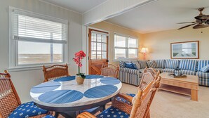 A living room with a round table, wicker chairs, a striped sofa, and a ceiling fan. - Walk to Beach: Ocean City Home w/ Deck & Views! (Ocean City)