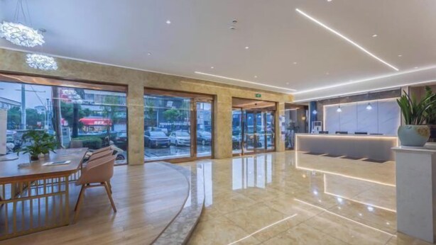 A modern hotel lobby with a reception desk, seating area, and large windows offering a view of the street. - Bojin Hotel (Cixi Zhouxiang Bus Station) (Cixi)