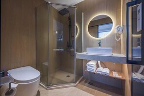 A modern bathroom with a glass-enclosed shower, a white sink with a mirror, and a towel rack. - Bojin Hotel (Cixi Zhouxiang Bus Station) (Cixi)