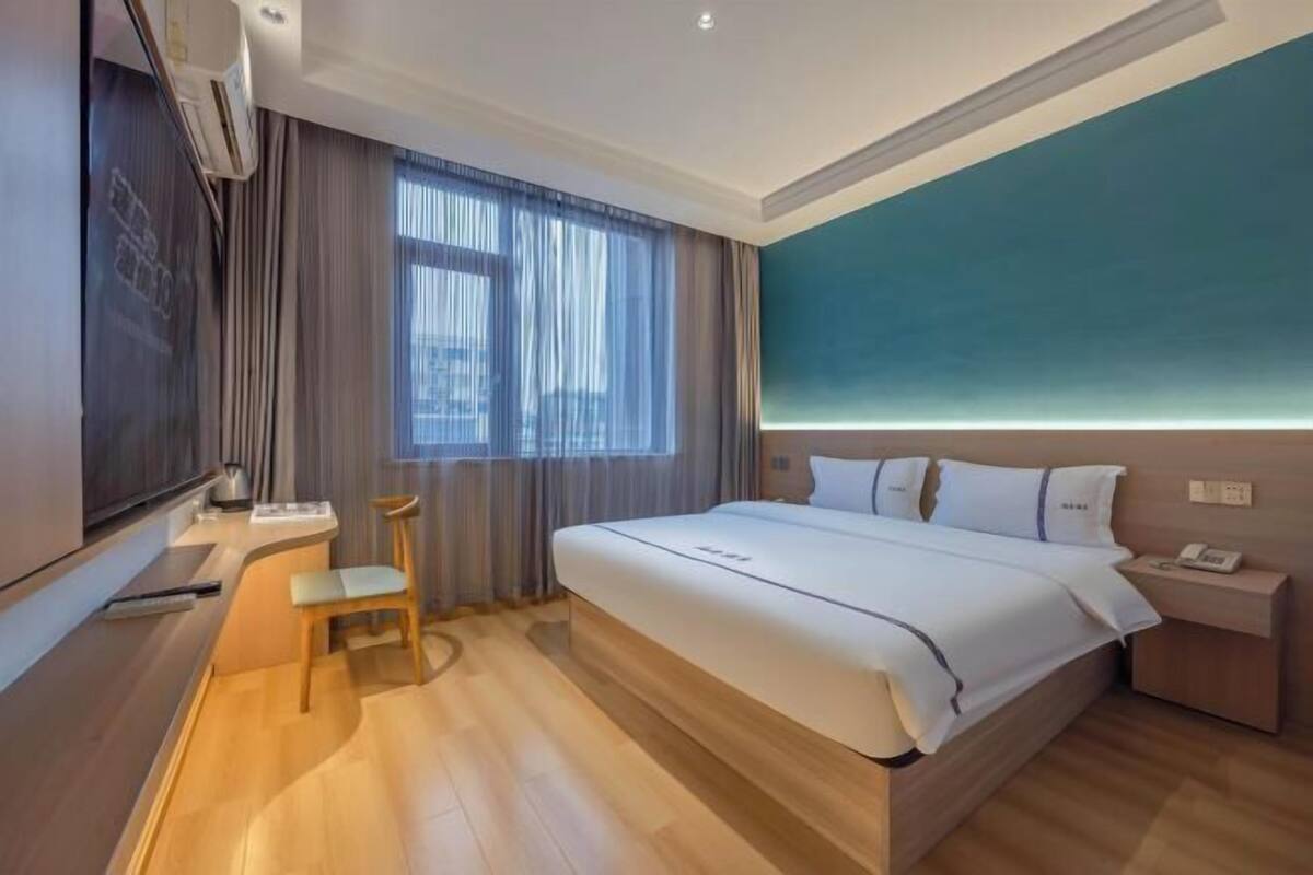 Una habitación de hotel moderna con una cama grande, un escritorio y una silla.