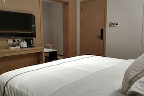 A hotel room with a bed, a TV, a coffee maker, and a desk. - Liuyang Longteng Business Hotel (Liuyang)