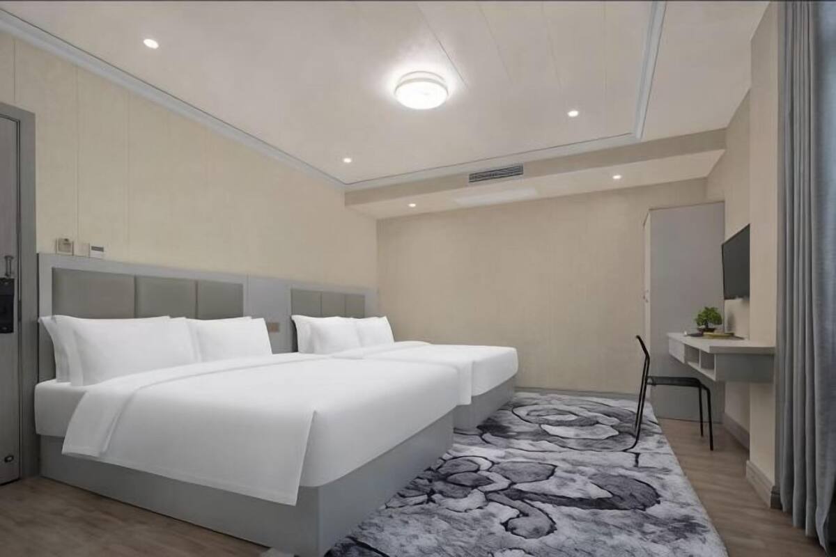 Ein modernes Hotelzimmer mit einem großen Bett, einem Schreibtisch und einem Stuhl.