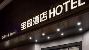 A hotel entrance with illuminated signage, a reception desk, and a well-lit facade. - Ningbo Daxiebaodao Island Hotel (Ningbo)