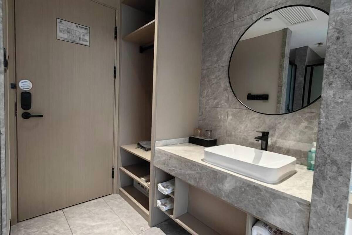 A modern bathroom with a built-in sink, a mirror, and a towel rack.