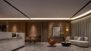 A modern lobby with a reception desk, seating area, and a sofa. - Ningbo Daxiebaodao Island Hotel (Ningbo)