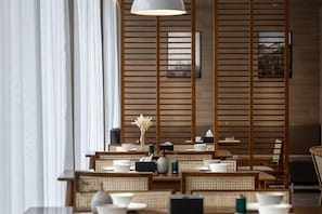 A restaurant with wooden slats, tables, chairs, and a hanging light fixture. - Ningbo Daxiebaodao Island Hotel (Ningbo)