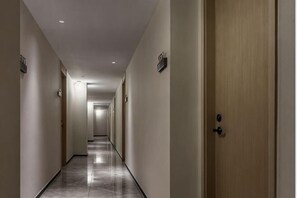 A long, narrow hallway with doors on both sides, leading to rooms. - Ningbo Daxiebaodao Island Hotel (Ningbo)