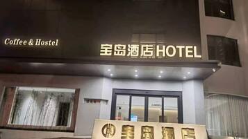 A hotel entrance with a sign indicating it's a 'Coffee & Hostel' and '星岛酒店HOTEL'.