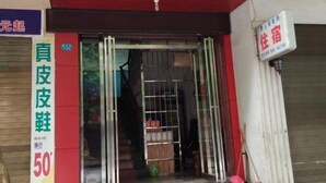 Entrada d'hotel amb una reixa metàl·lica, un cartell que indica un preu especial i un persianes tancat a la dreta.