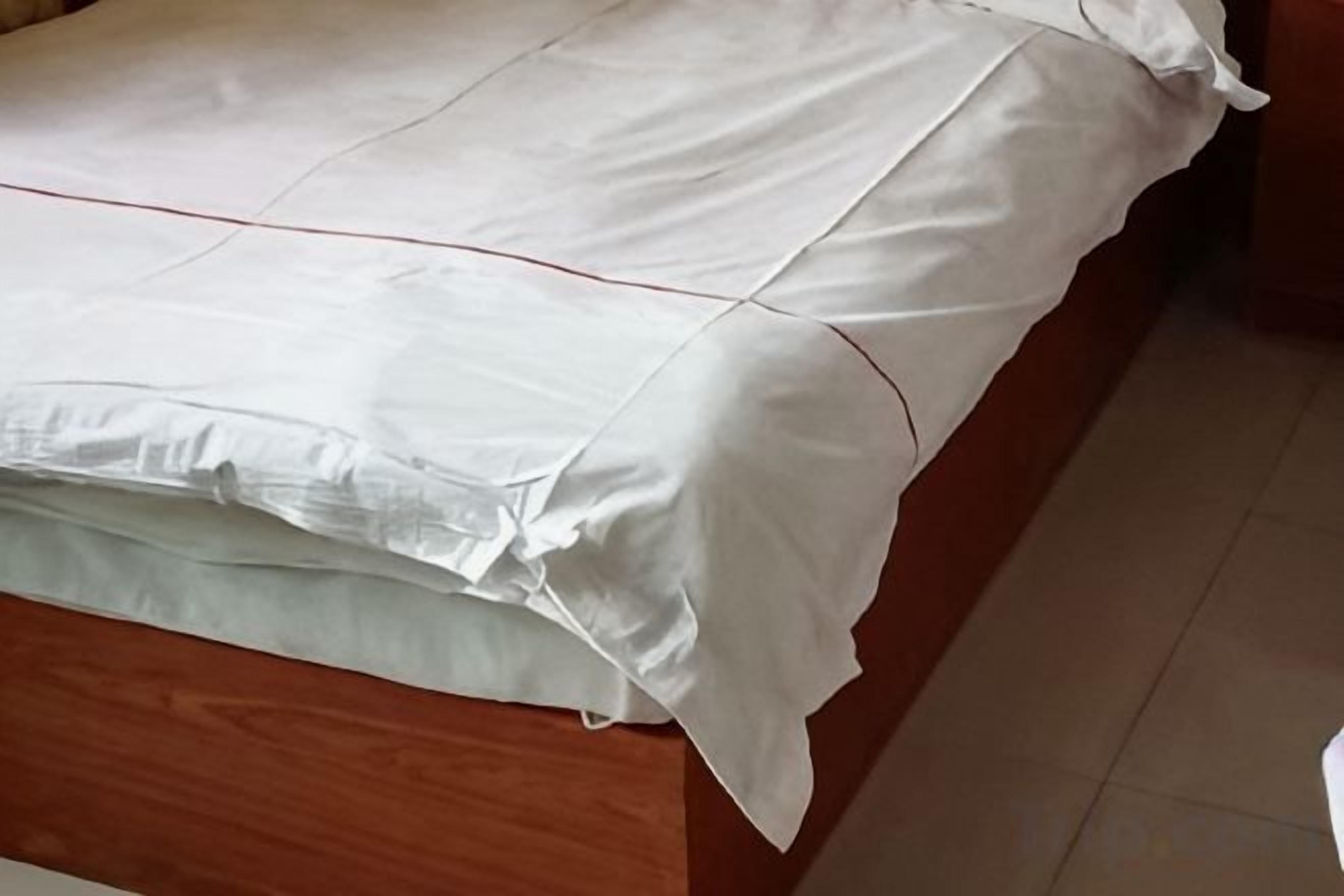 A bed with a white bedspread and pillows.