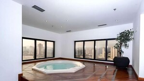 A spacious room with a hot tub, large windows, and a city view. - Flat Hotel GRU SL Guarulhos (Guarulhos)