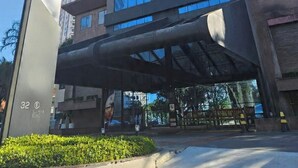 A tall building with a modern glass facade and a covered entrance area. - Flat Hotel GRU SL Guarulhos (Guarulhos)