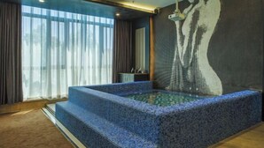 A spa area with a hot tub, a large window with curtains, and a wall with a textured pattern. - Jiyi Hotel (Yining Beijing Road Branch) (Yining City)