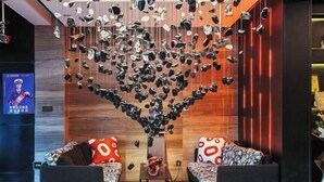 A modern lobby with two sofas, a coffee table, and a unique ceiling art installation. - Jiyi Hotel (Yining Beijing Road Branch) (Yining City)