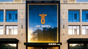A modern hotel facade with a prominent 'JOY HOTEL' sign. - Jiyi Hotel (Yining Beijing Road Branch) (Yining City)