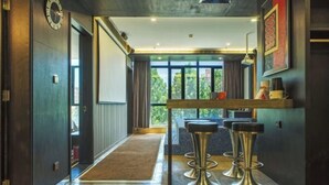 A modern interior with a bar area featuring stools, a clock, and a view through large windows. - Jiyi Hotel (Yining Beijing Road Branch) (Yining City)