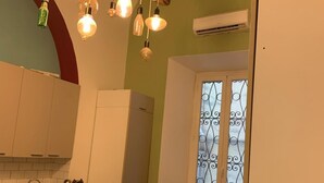 Una cocina compacta con comedor, que incluye una mesa de madera, sillas y un mantel colorido.