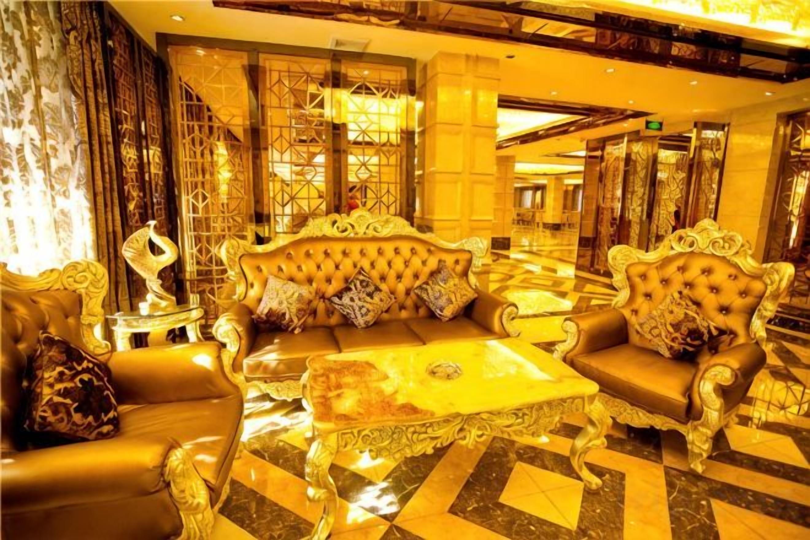 A luxurious lobby with ornate sofas, a patterned coffee table, and a decorative sculpture.