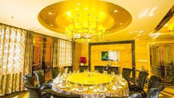 A formal dining room with a round table, chairs, and a chandelier.