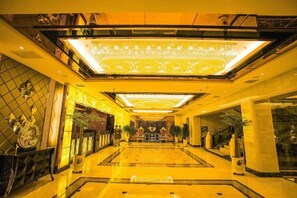A hotel lobby with a grand chandelier, a central staircase, and a large reception desk. - Xiaolajiao Hotel (Zhangye Jinzuo) (Zhangye)