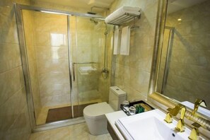A modern bathroom with a glass-enclosed shower, a toilet, and a sink with gold fixtures. - Xiaolajiao Hotel (Zhangye Jinzuo) (Zhangye)
