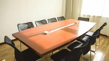 A conference room with a long table, six chairs, and a whiteboard.