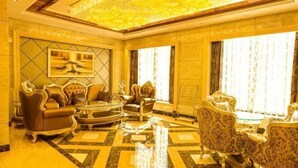A luxurious lobby with a chandelier, a round coffee table, and a sofa set.
