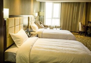 A hotel room with two beds, a headboard, a desk, a chair, a lamp, and a window with curtains. - Xiaolajiao Hotel (Zhangye Jinzuo) (Zhangye)
