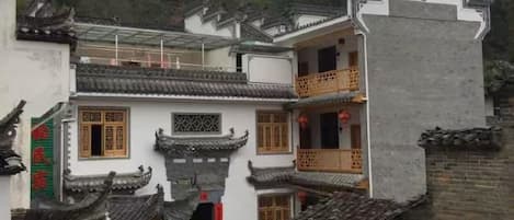 Un patio tradicional con edificios de varios pisos, un espacio abierto central y una pared que lo rodea.