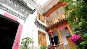 A traditional Chinese courtyard with a wooden balcony, potted plants, and a red lantern. - Huiyun Homestay, Yuli Ancient Town (Fuliang)
