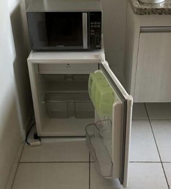 Une cuisine de taille réduite, équipée d’un four à micro-ondes et d’un réfrigérateur.
