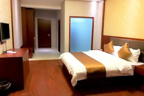 Habitació d'hotel amb un llit, una taula de treball i una televisió.