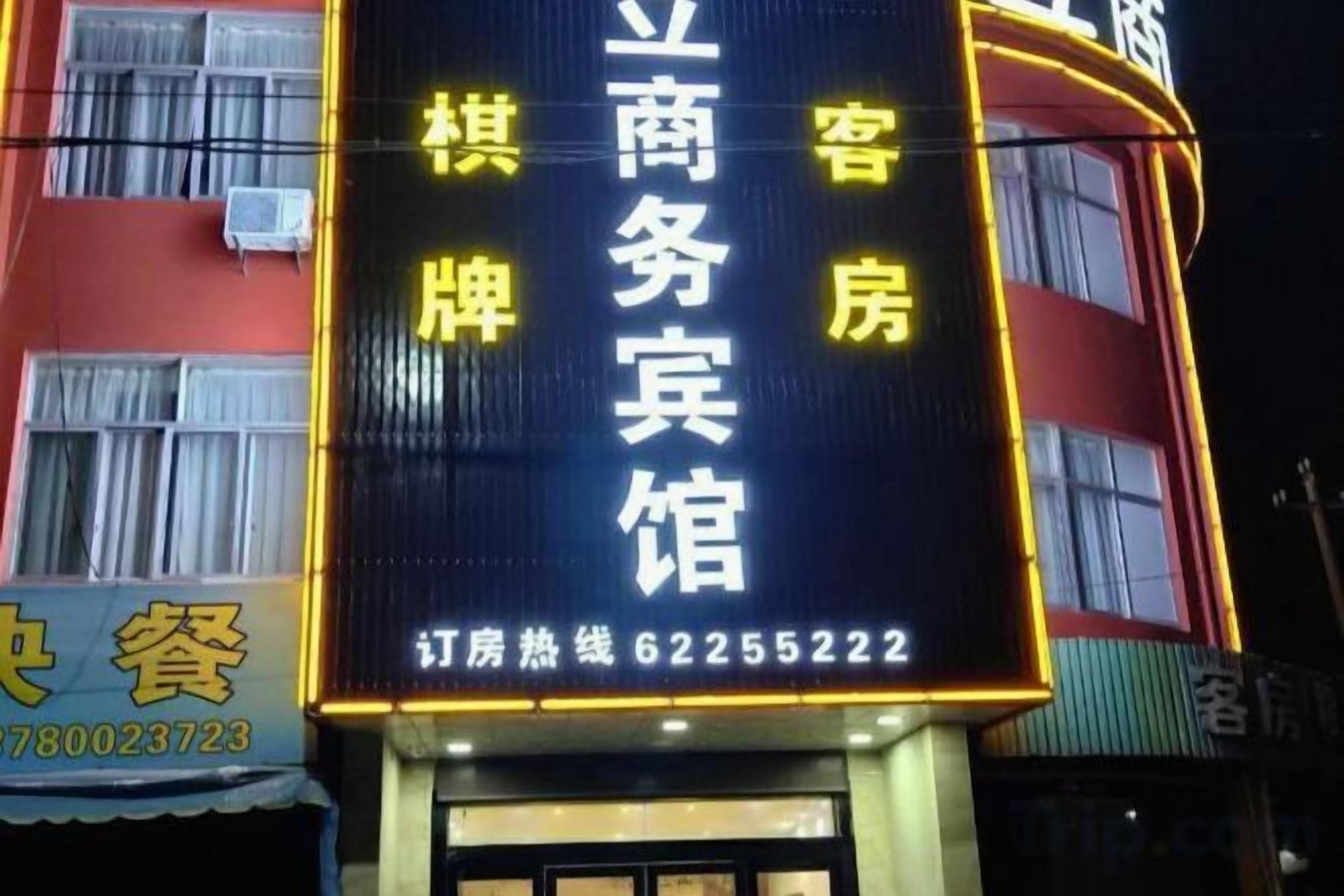 A hotel sign with Chinese characters, a phone number, and a website address.