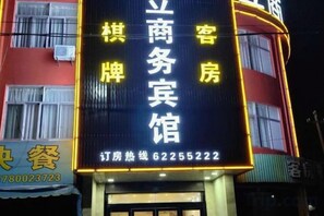 A hotel sign with Chinese characters, a phone number, and a website address. - Guli Business Hotel (Yuyao)
