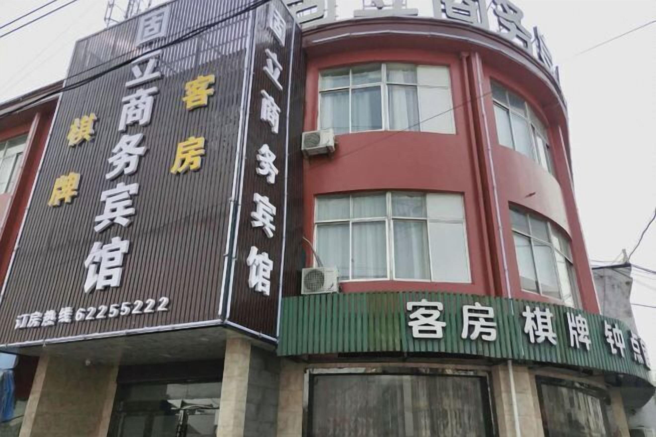 A building with signage for a business and a guesthouse.