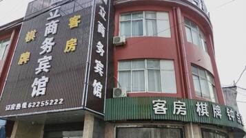 A building with signage for a business and a guesthouse.