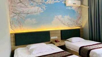 A hotel room with two beds, a wall mural, a nightstand, and a window with curtains.